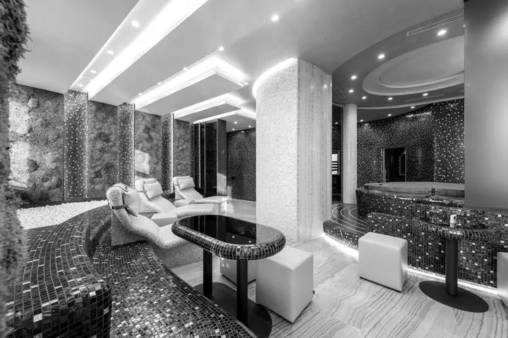 A calm spa lounge with loungers and mosaic walls