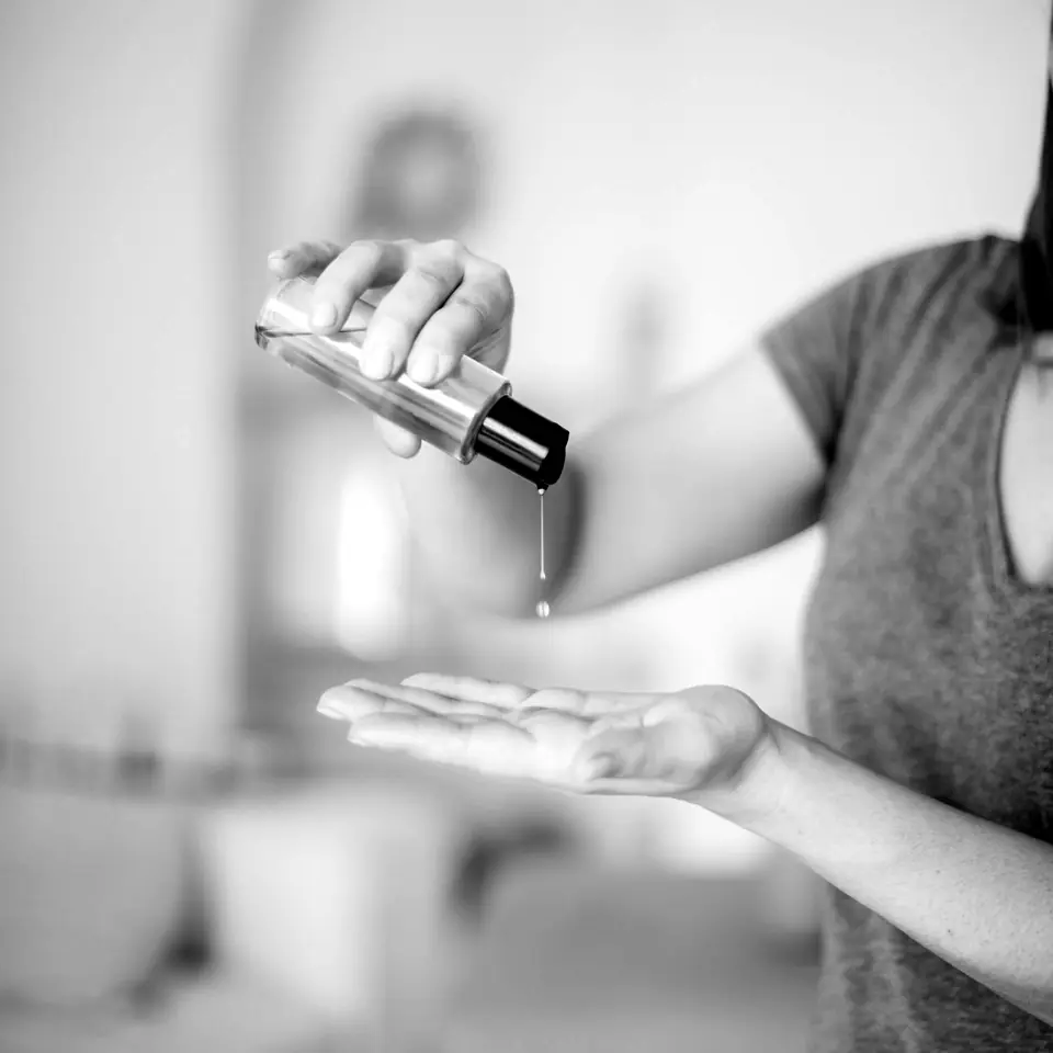 Massage oil poured into a therapist's palm
